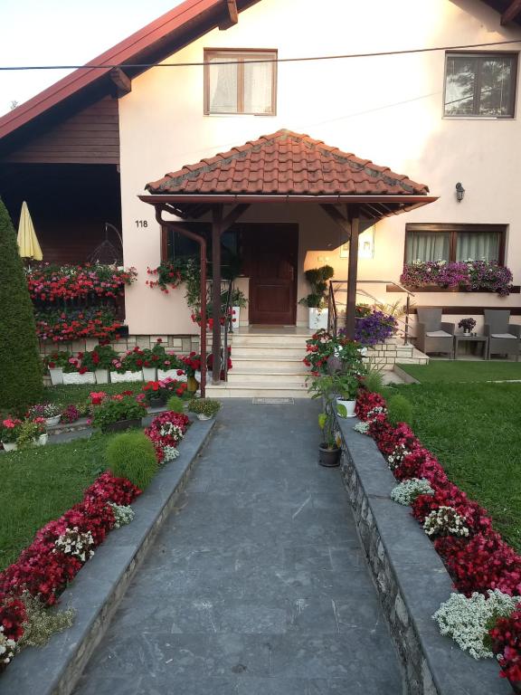 a house with a gazebo and flowers at Apartment Vihor in Zlatibor
