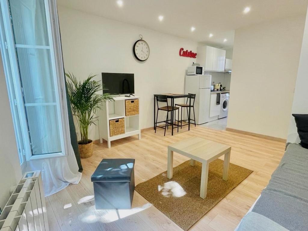 un salon avec un canapé et une table et une cuisine dans l'établissement SYDEL, à Paris