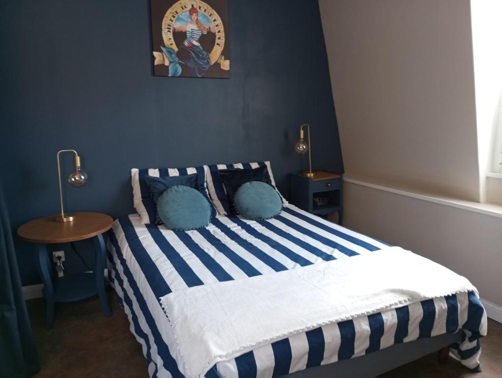 a bedroom with a bed with blue and white stripes at Chambre avec salle d'eau privative in Dunkerque