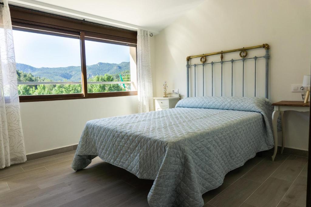 sypialnia z łóżkiem i dużym oknem w obiekcie Casa rural Mirador del Río Tus, en Yeste w mieście Yeste
