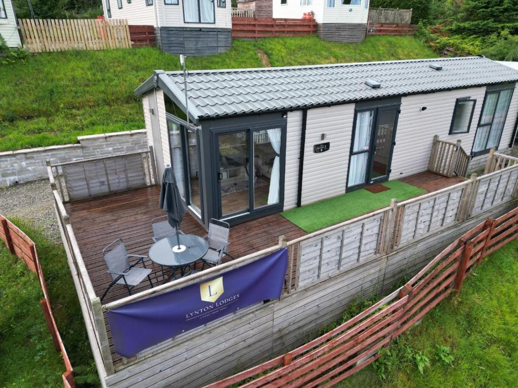 a house with a deck with a table on it at Lynton lodges in Evanton