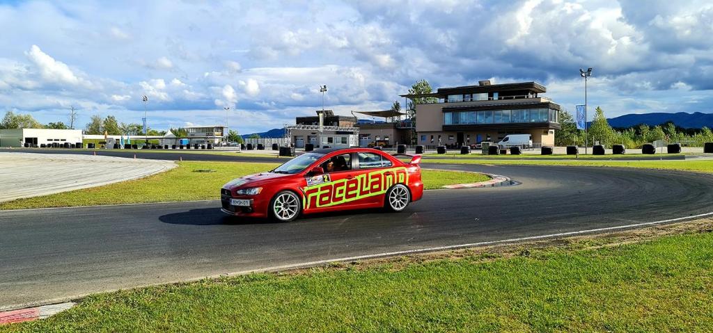 un coche rojo está conduciendo en una pista de carreras en Raceland Krško, en Krško