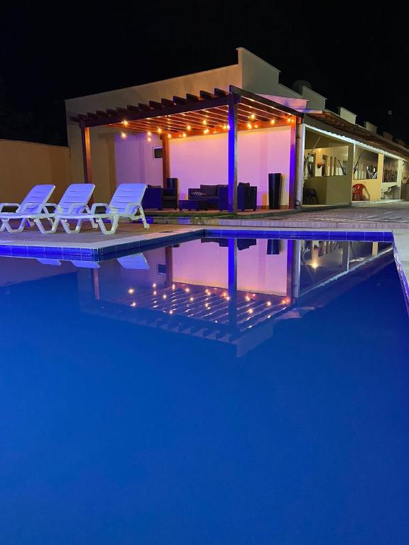 a swimming pool with two chairs and a house at Dunas residence casa 15- Lençois Maranhense in Santo Amaro