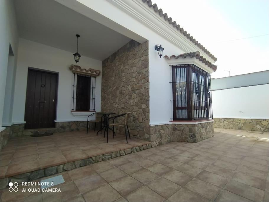 un patio de una casa con mesa y sillas en Casa La Alquería en Chiclana de la Frontera