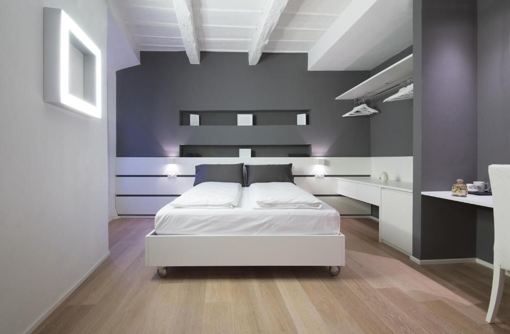 コモにあるComo Luxury Roomsのベッドルーム1室(白いベッド1台、青い壁付)