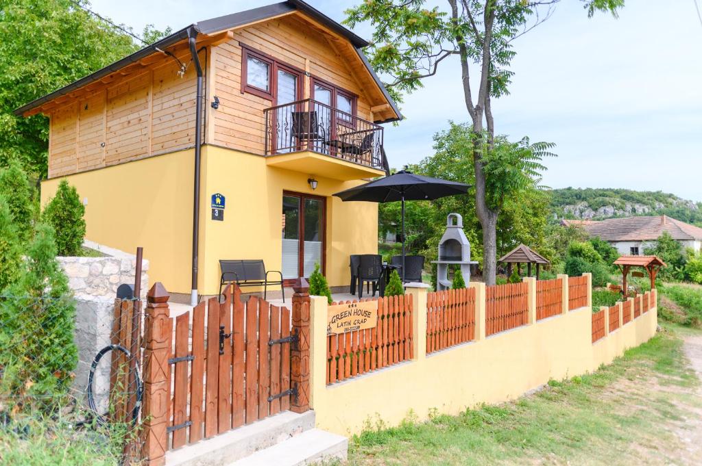 a house with a wooden fence and a balcony at Green House Latin Grad in Vrmdža