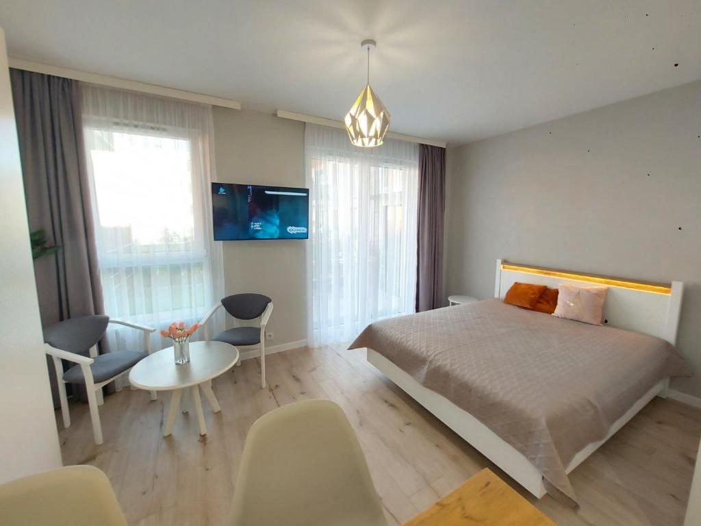 una camera da letto con un letto, un tavolo e delle sedie di LuxApartmentWarszawa z bezpłatnym podziemnym parkingem a Varsavia