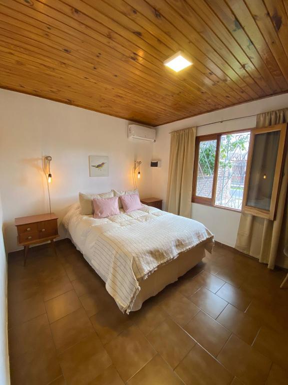 1 dormitorio con 1 cama grande y techo de madera en Casa 2 habitaciones en barrio céntrico en San Rafael