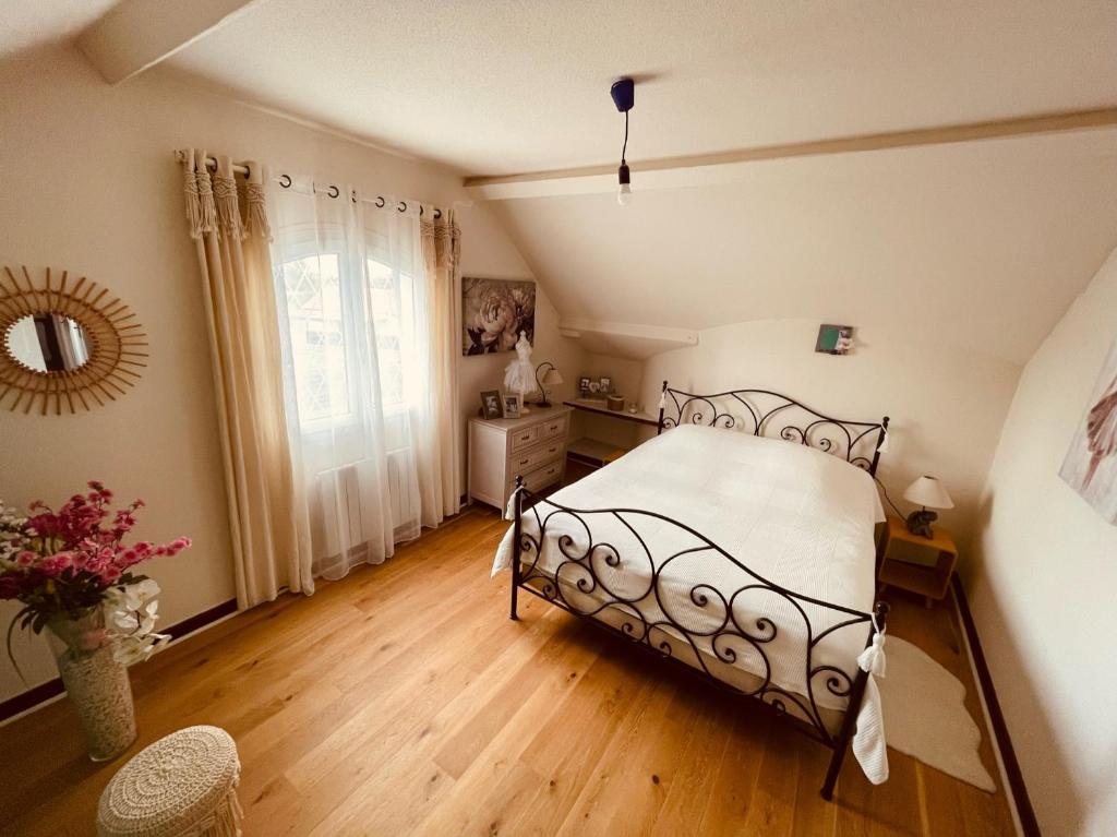 a bedroom with a bed and a wooden floor at Le Mas aux Papillons in Vendat