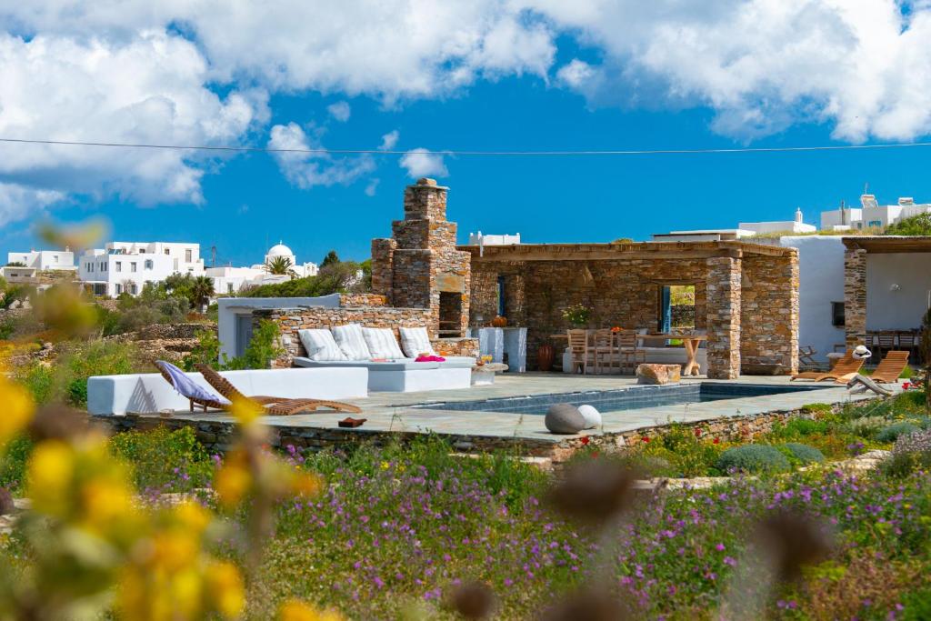 a house with a pool in a field of flowers at Sifnos Themonies in Apollonia