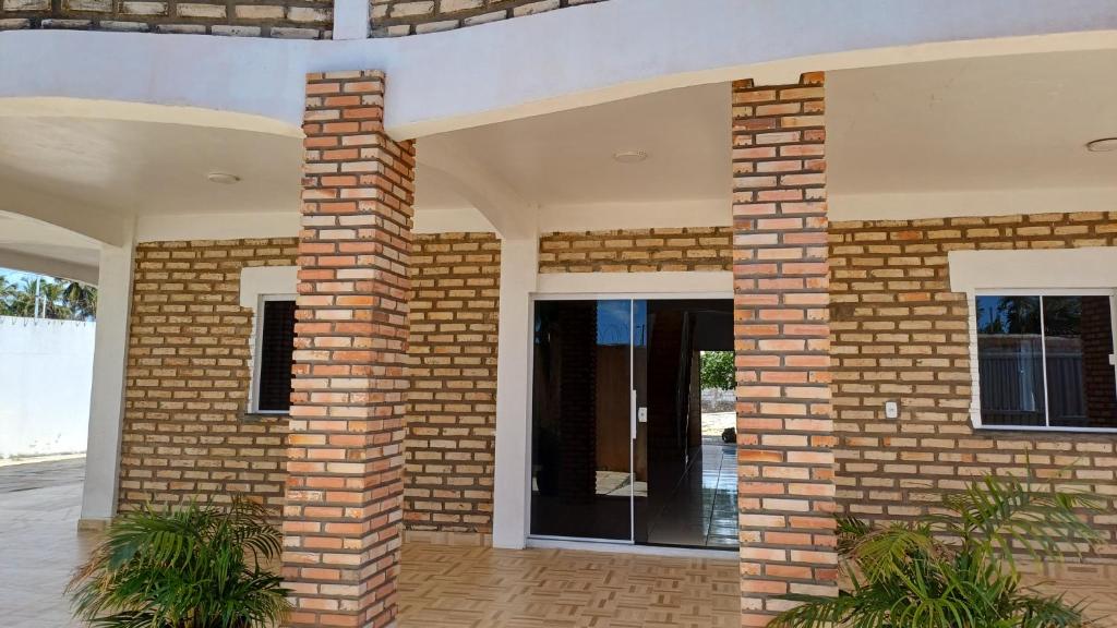 uma parede de tijolos com uma porta numa casa em Pousada Farol da Barra em Tutóia