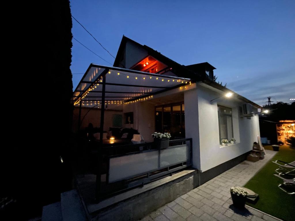a house with a balcony with lights on it at Nóra Apartman in Balatonkenese