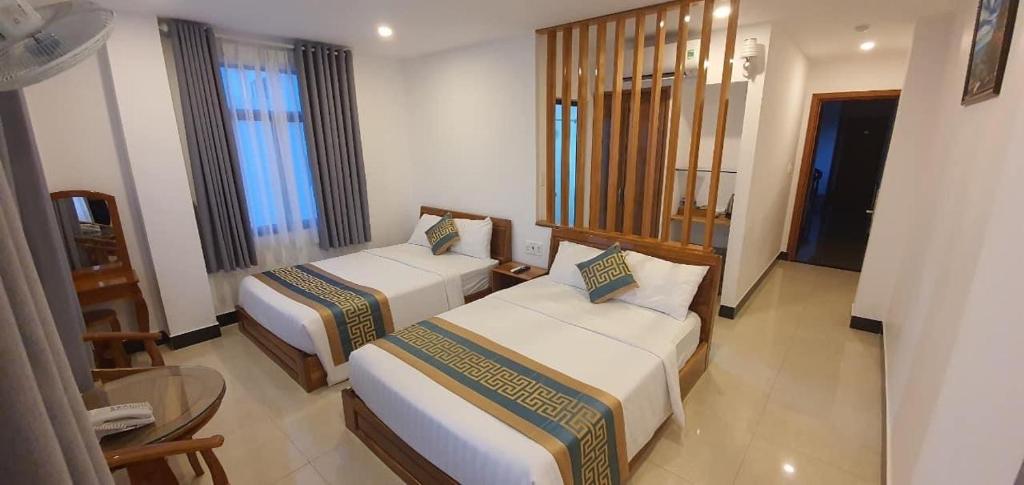 a hotel room with two beds and a table at Luxury hotel Phú Yên in Liên Trì (3)