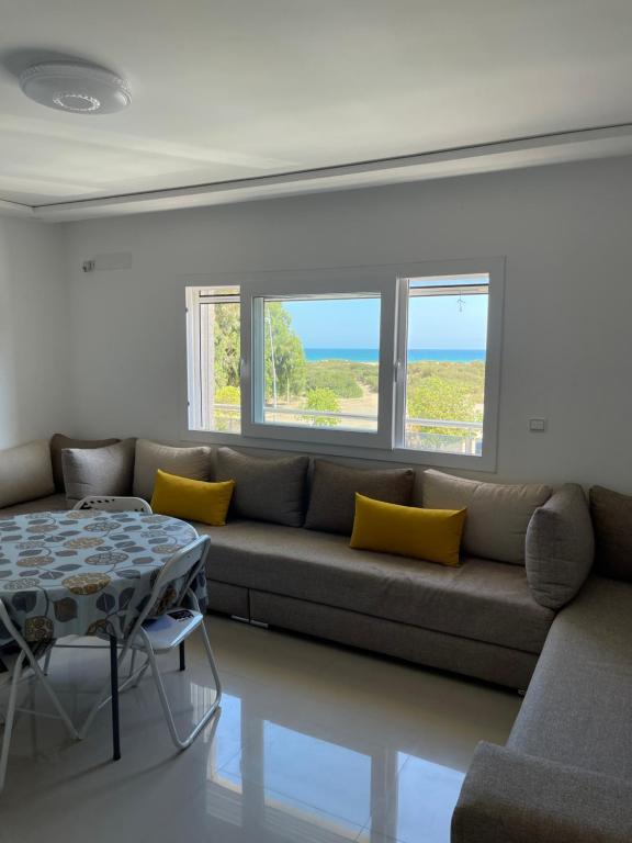 sala de estar con sofá y mesa en appartement vue sur mer saidia en Saïdia