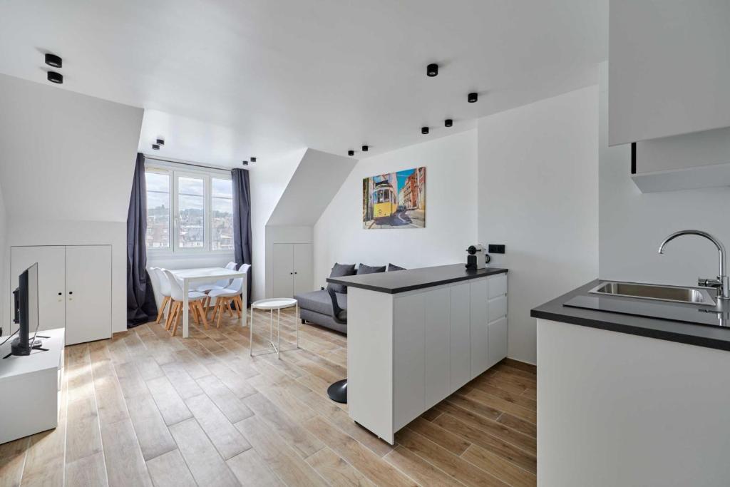 une cuisine avec des armoires blanches et un salon dans l'établissement Studio au coeur de Deauville, proche Place Morny, à Deauville