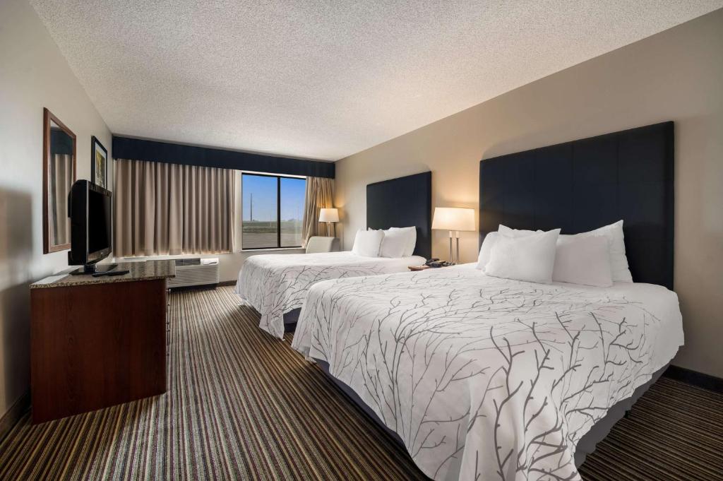 a hotel room with two beds and a flat screen tv at Best Western Park Oasis Inn in Mauston