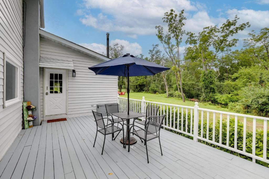 una mesa con sillas y una sombrilla en una terraza en Pennington Home with Deck about 9 Mi to Princeton! 