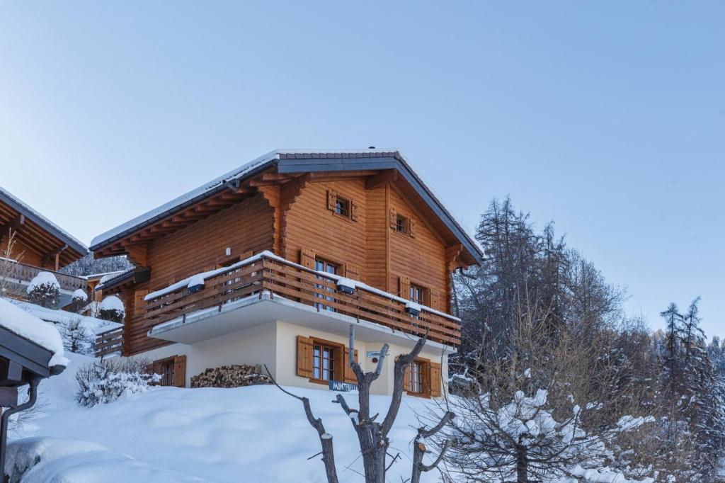 a log cabin in the snow with snow covered trees at Montebello Cozy, classic Swiss chalet with stunning views in La Tzoumaz