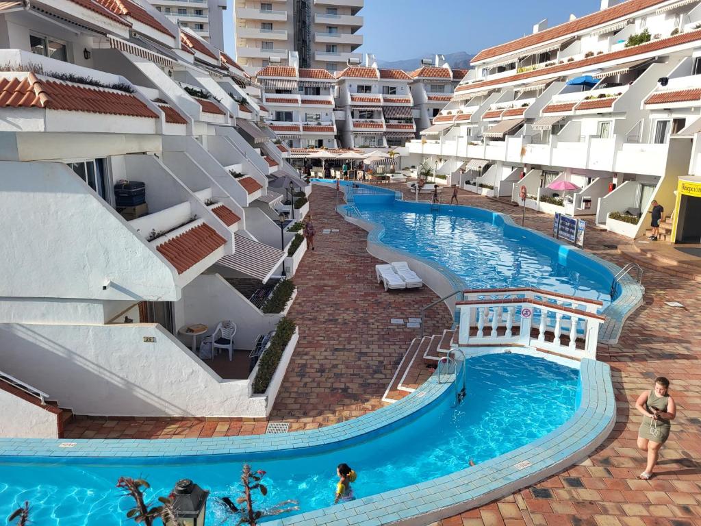 an aerial view of a swimming pool next to buildings at NEWQUAY in Playa de las Americas
