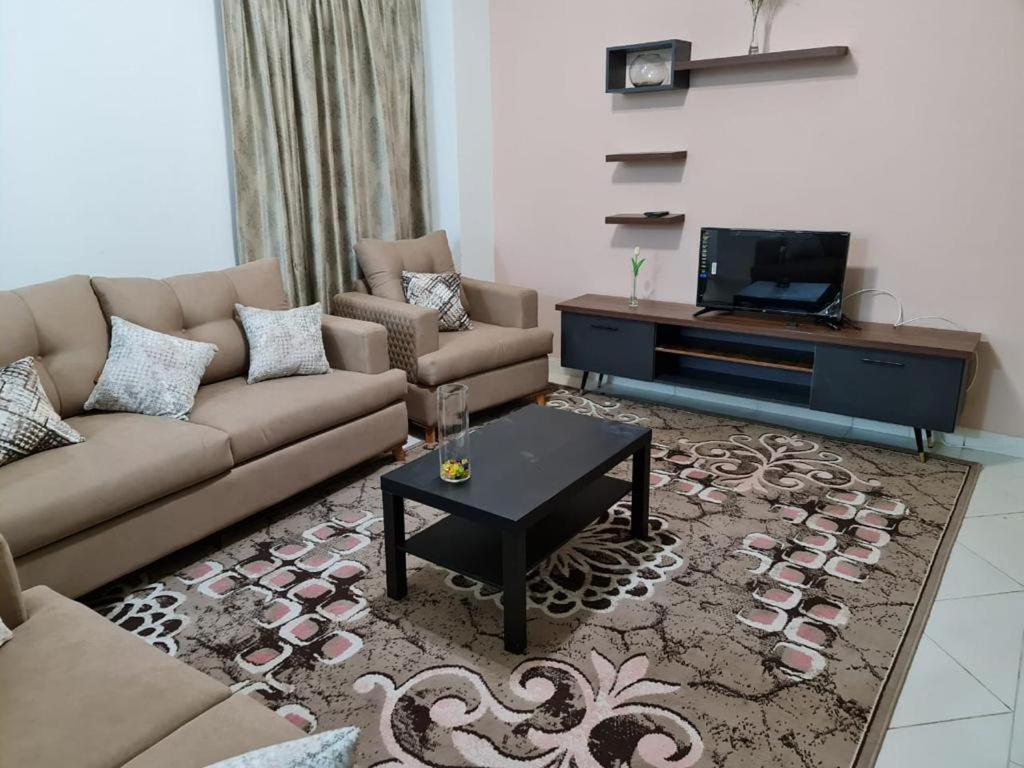 a living room with a couch and a tv at Marassi in Sīdī ‘Abd ar Raḩmān