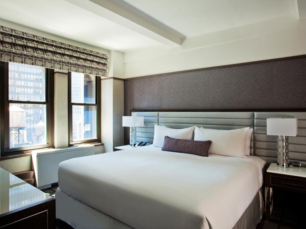 1 Schlafzimmer mit einem großen weißen Bett und 2 Fenstern in der Unterkunft Park Central in New York