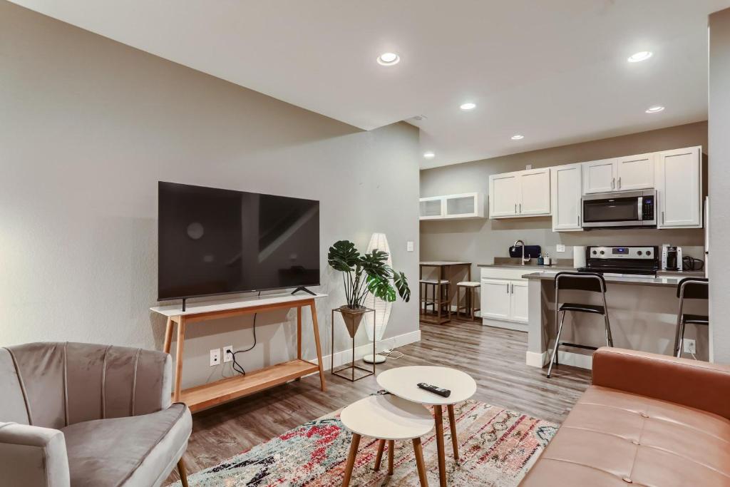 a living room with a couch and a flat screen tv at Central Park - 28th Place Apt in Aurora