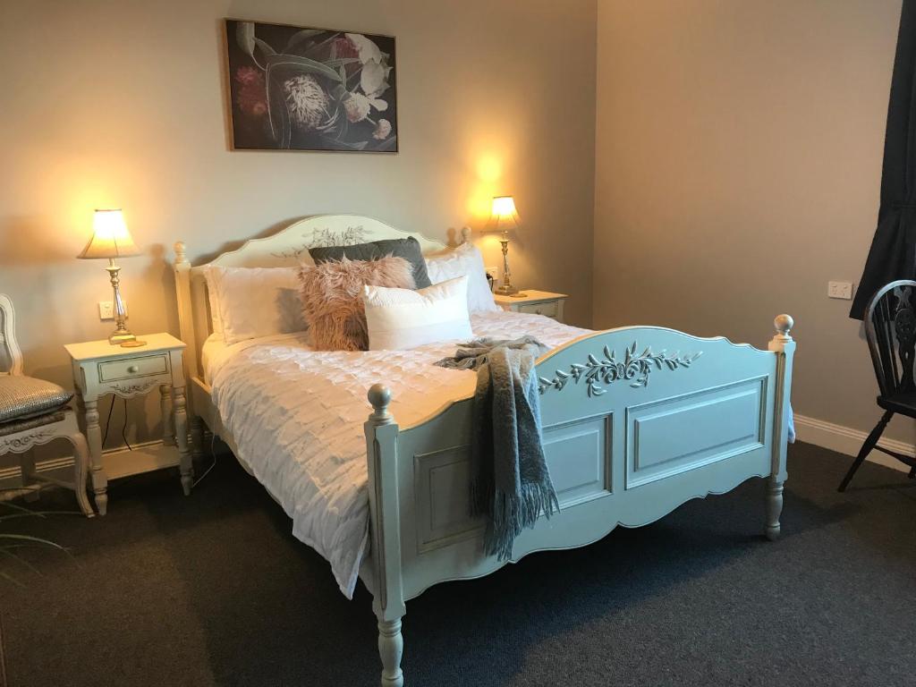 Un dormitorio con una cama azul con almohadas en Number 10 -Queen Room with b/fast, en Stanley