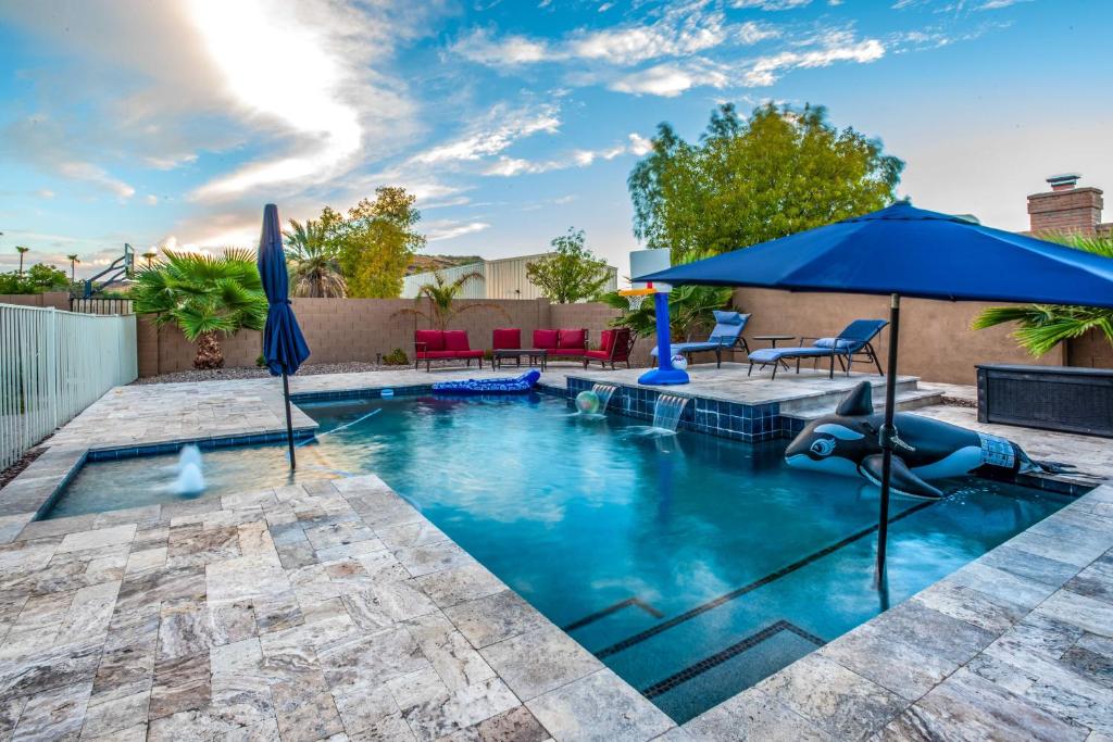 a pool with an inflatable dolphin in the middle at Pet-Friendly Glendale Home with Pool and Putting Green in Phoenix