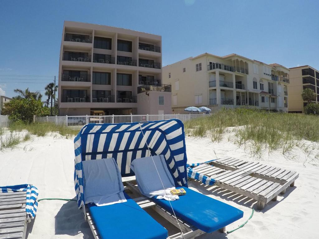 un par de sillas de playa sentadas en la arena en la playa en Island Gulf Resort, a VRI resort, en St Pete Beach