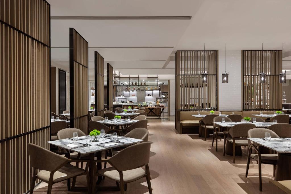 un restaurante con mesas y sillas y un bar en Courtyard by Marriott Shenzhen Northwest, en Bao'an