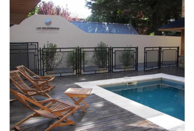 - deux chaises longues et une piscine dans la cour dans l'établissement Las Golondrinas - UF 319, à San Martín de los Andes