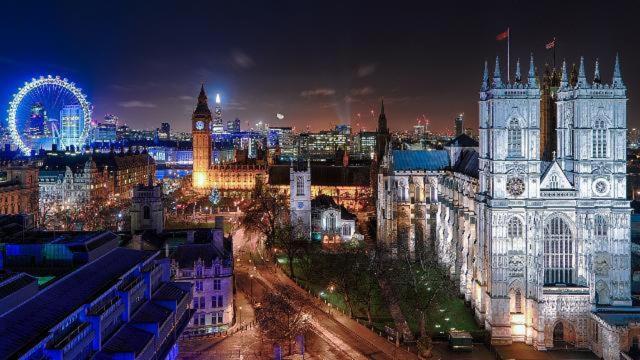 a lit up city at night with a clock tower at 18K HOME FROM HOME in London