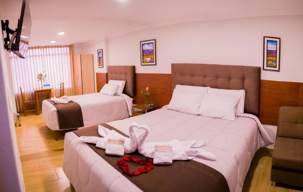 Habitación de hotel con 2 camas y toallas. en Hostal Samakuy AQP en Arequipa