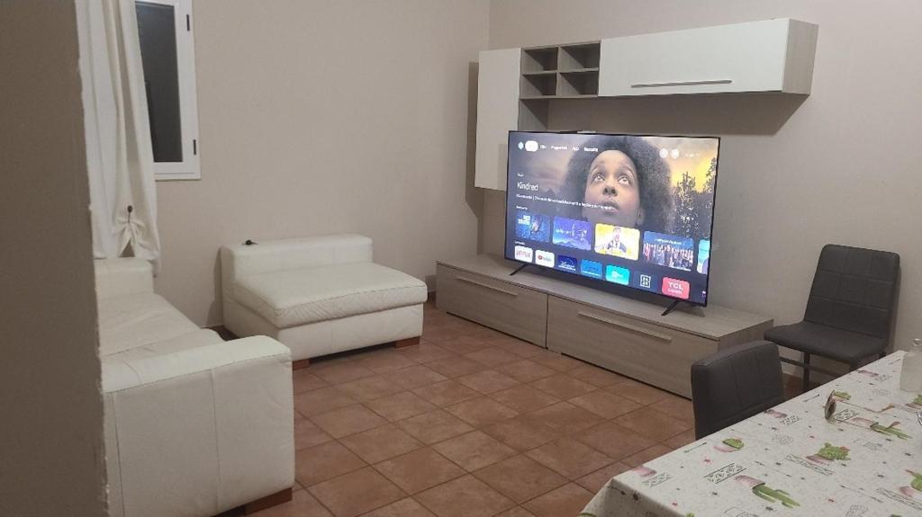 uma sala de estar com uma grande televisão de ecrã plano em Casa vacanze palagianello em Palagianello