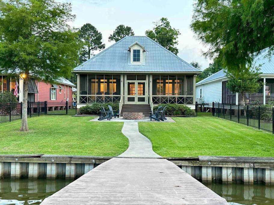 a house with a walkway next to a body of water at Drake on the Lake - False River, LA 