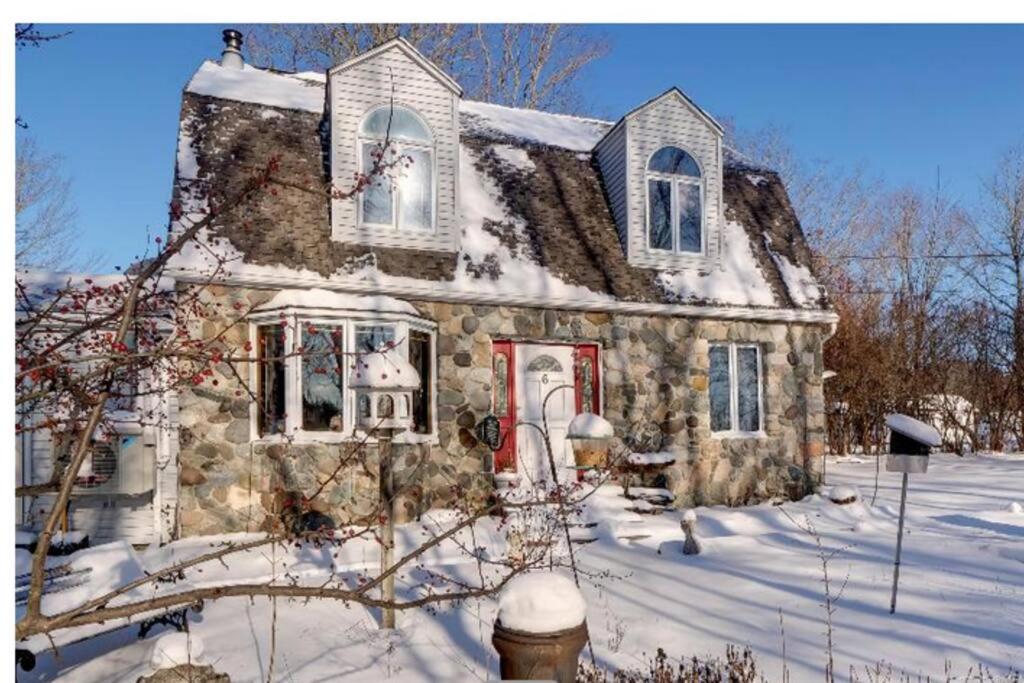 a stone house with a red door in the snow at 3 Bedroom 2 Bath Carriage House (Pet Friendly) in Bar Harbor