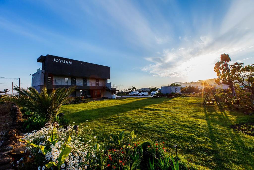 a building with a lawn in front of a building at Joyuam Jeju in Seogwipo