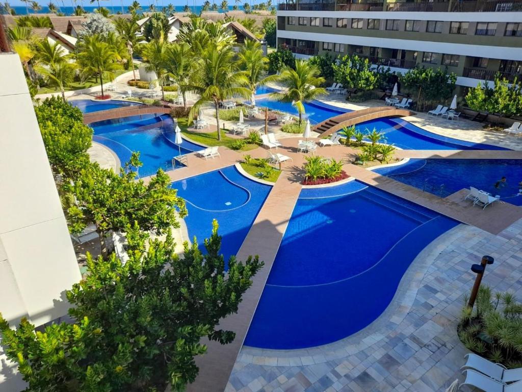 eine Aussicht über ein Resort mit blauen Pools in der Unterkunft Flat Duplex - Muro Alto Malawí in Porto De Galinhas