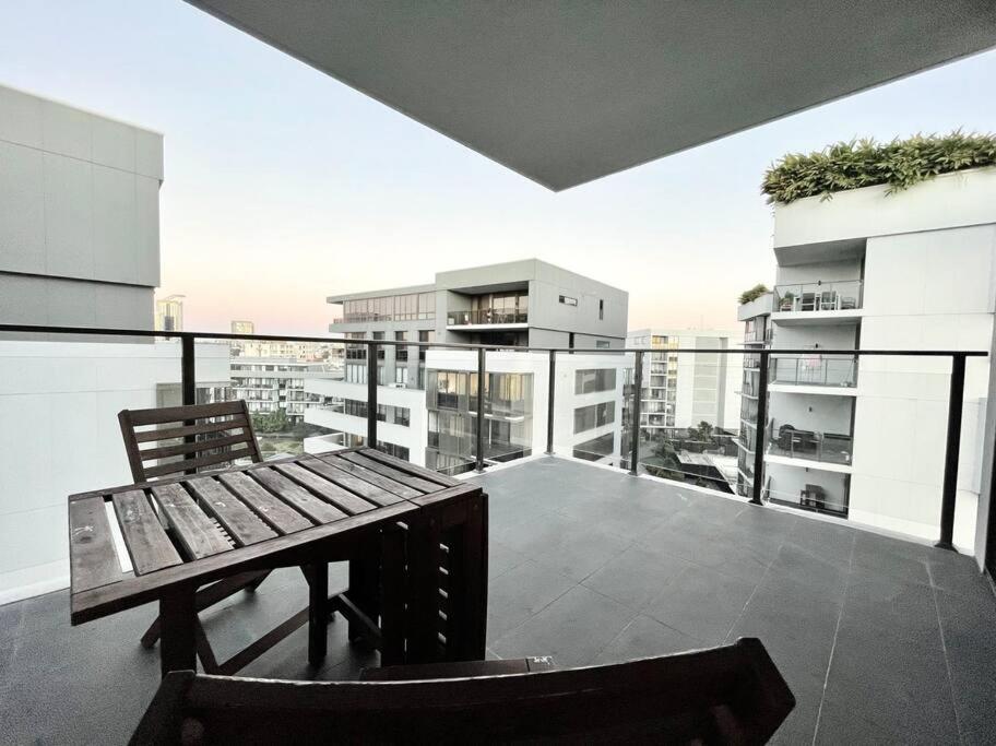 a balcony with a bench and a view of a building at SkyPark Oasis Retreat 2Br@ close to Olympicpark in Sydney