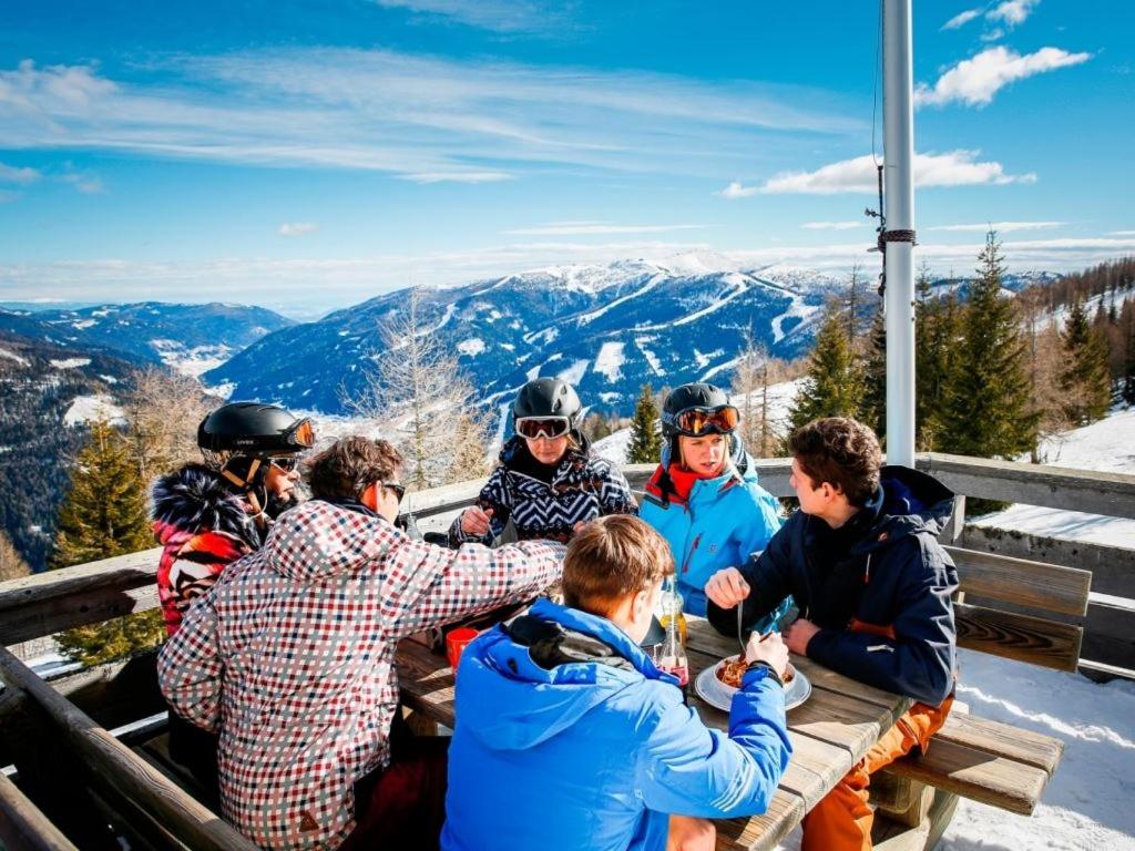 a group of people sitting at a table in the snow at Landal Bad Kleinkirchheim in Bad Kleinkirchheim