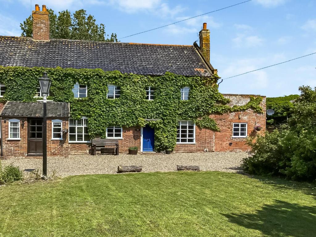 an old brick house with a blue door at Middle Farm in East Harling