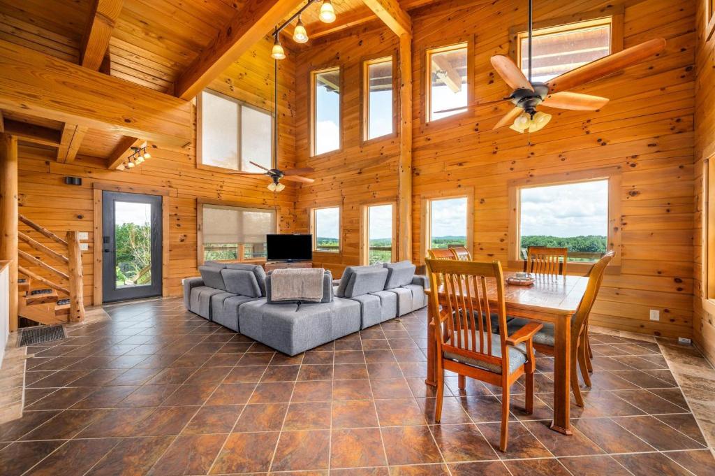 uma sala de estar com um sofá e uma mesa em Panoramic Paradise 3BR Cabin with Idyllic Views 