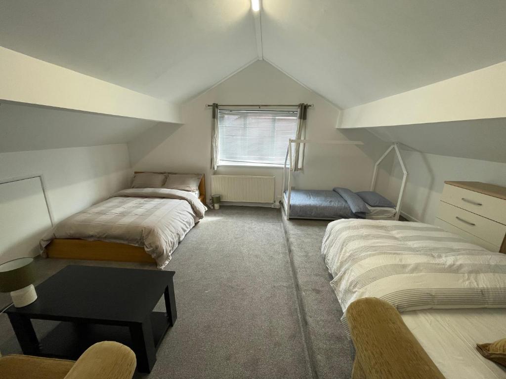 um quarto no sótão com 2 camas e uma secretária em Bethel Apartments em Leeds
