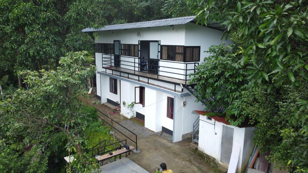 an overhead view of a white house with trees at The Meadows INN in Kottayam