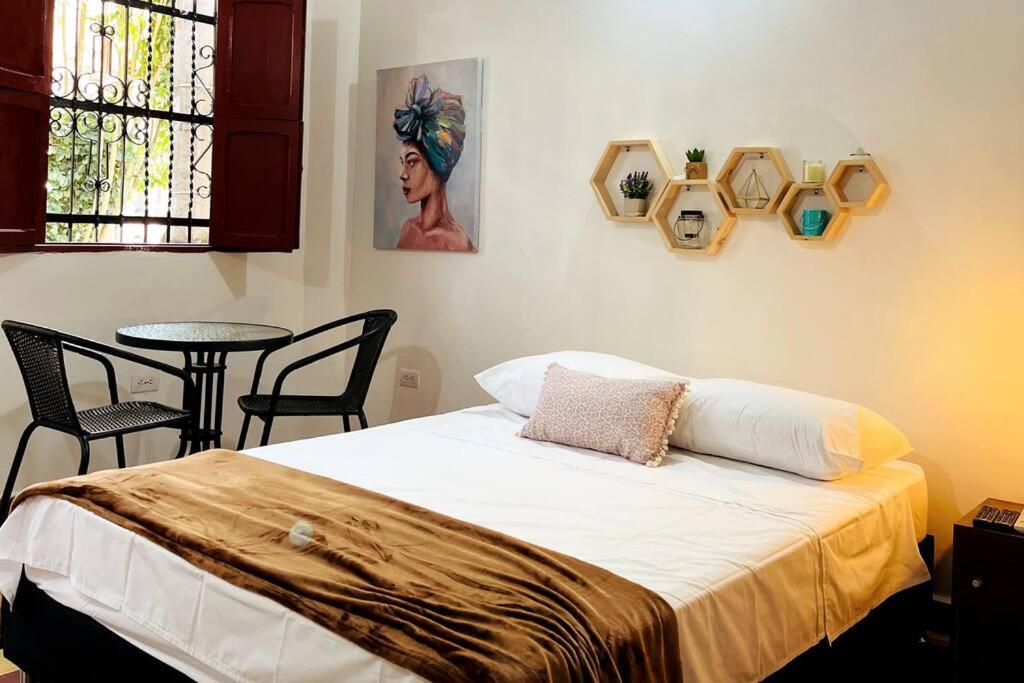 Schlafzimmer mit einem Bett und einem Tisch mit Stühlen in der Unterkunft Apartaestudio Colonial, Aire Acondicionado, wifi 200 Mbps in Envigado