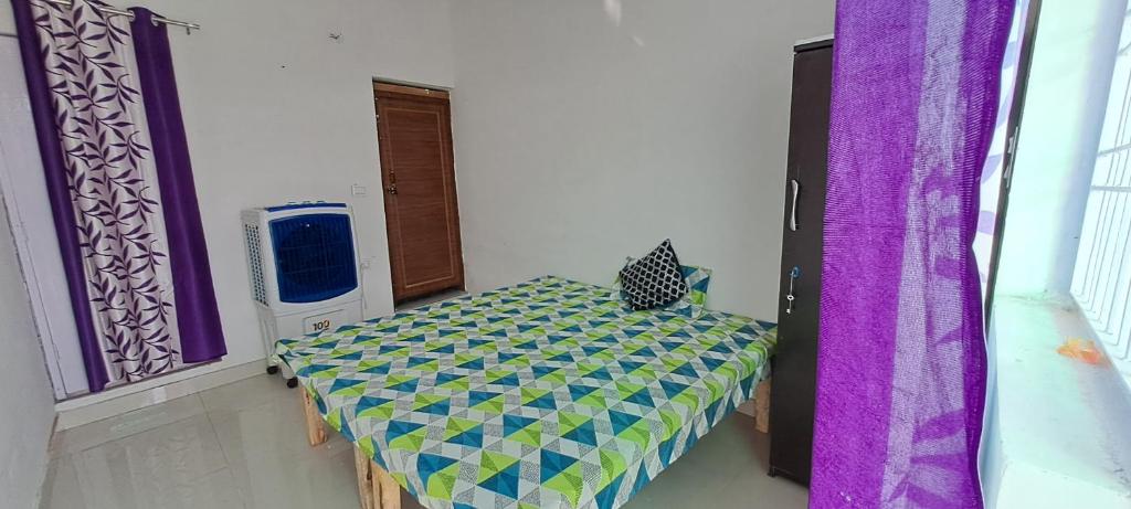 Cette chambre comprend un lit dans un dortoir doté de rideaux violets. dans l'établissement Vrinda homestay, à Vrindavan