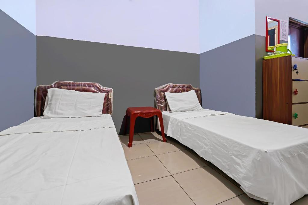 twee bedden naast elkaar in een kamer bij OYO 92893 Santana Residence Syariah in Bojongsalam