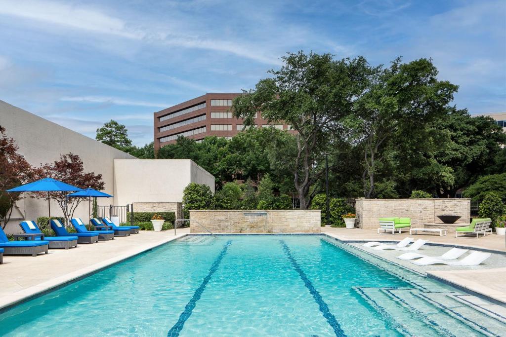 a swimming pool with chairs and a building at Dallas-Addison Marriott Quorum by the Galleria in Dallas