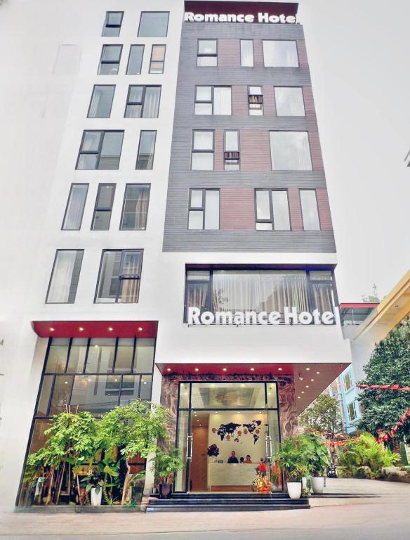 a tall white building with a store front at Romance hotel in Cat Ba
