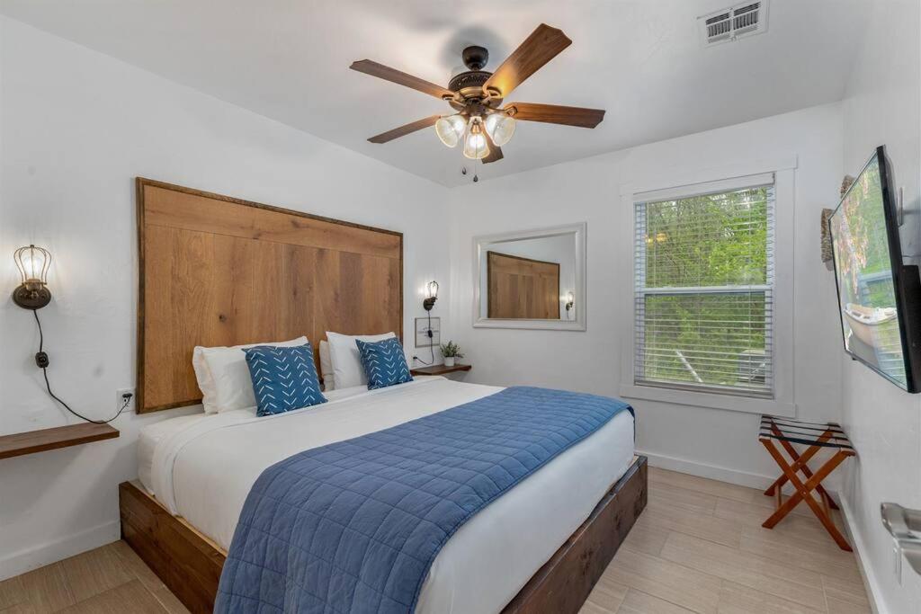 a bedroom with a bed with a ceiling fan at Cozy Cottage • King Bed • Grove • Kayaks • Boat Parking in Grove